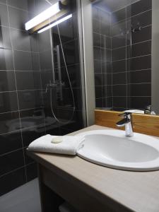 La salle de bains est pourvue d'un lavabo et d'une douche. dans l'établissement Le Lioran Studio les Myrtilles à 200m des pistes, à Le Lioran