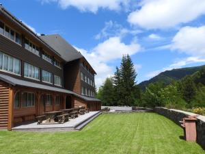 a building with a grass yard in front of it at Le Lioran Studio les Myrtilles à 200m des pistes in Le Lioran