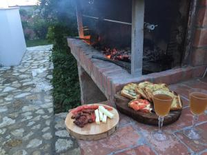 una mesa con dos platos de comida y dos copas de vino en Xuxi Apartments, en Lukovë
