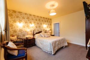 a bedroom with a bed and a chair at Cawley's Guesthouse in Tobercurry