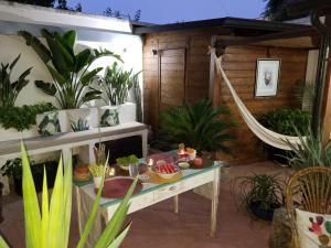 een patio met planten en een tafel en een hangmat bij El Quinto Sol B&B in Copertino