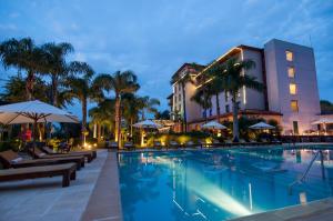 a hotel with a swimming pool in front of a building at Panoramic Grand - Iguazú in Puerto Iguazú