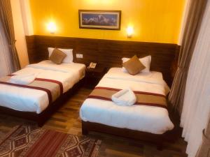 En eller flere senger på et rom på Hotel Guru