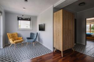 a living room with two chairs and a cabinet at Villa Orla Gdynia in Gdynia