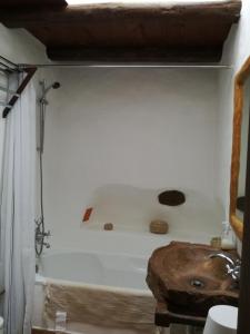 e bagno con parete bianca e vasca. di Oliveira Surf House Ericeira a Santo Isidoro Altre 24 foto