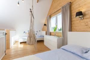a bedroom with a swinging bed and a window at Kompleks Wypoczynkowy Bryza III in Lubiatowo