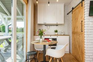 a kitchen and dining room with a table and chairs at Kompleks Wypoczynkowy Bryza III in Lubiatowo