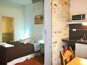 a bedroom with a bed and a kitchen with a table at Descanso las Tres Marias Apart Hotel in Villa Carlos Paz