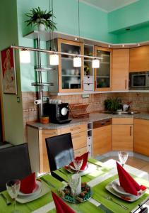 uma cozinha com uma mesa com cadeiras vermelhas e uma mesa com sidx sidx sidx em Apartment Villa Frank em Mariánské Lázně