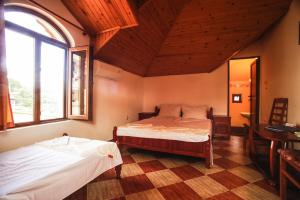 a bedroom with two beds and a large window at Guest House Yoanna in Balchik