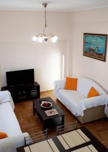 ein Wohnzimmer mit einem weißen Sofa und einem Tisch in der Unterkunft Stylish apartment near Katechaki in Athen