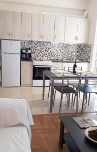 een keuken met een tafel en een witte koelkast bij Stylish apartment near Katechaki in Athene