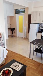 een woonkamer met een tafel en een gele deur bij Stylish apartment near Katechaki in Athene