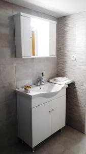 een badkamer met een witte wastafel en een spiegel bij Stylish apartment near Katechaki in Athene