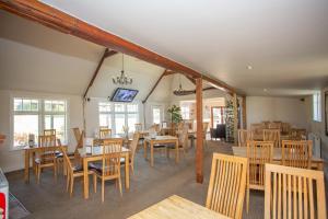 a dining room with wooden tables and chairs at Links Country Park Hotel in Cromer