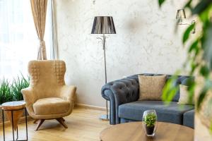 a living room with a blue couch and a chair at City Avenue Hotel by HMG-Free Parking-Free Wi-Fi in Sofia
