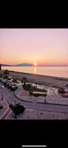 a sunset over a beach with a parking lot at Villa Un bel posto Sea View in Nea Vrasna