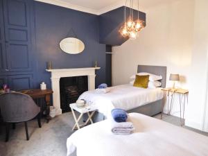 a blue bedroom with two beds and a fireplace at Rosalind House in Carlisle +24 photos