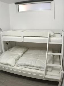 a white bunk bed with white pillows on it at Ferienwohnung Steffi Marina Wendtorf in Wendtorf
