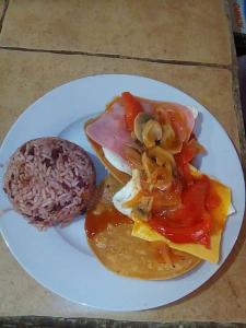 um prato de comida com uma sanduíche e um hambúrguer em Hostel Sunset Villas Popoyo em Popoyo