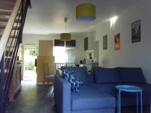 sala de estar con sofá azul y cocina en Saumur Loire Chambres et Gîte en Vernantes