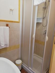 La salle de bains est pourvue d'une douche avec une porte en verre. dans l'établissement Agriturismo Le Folaghe, à Terracine