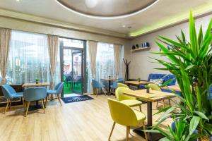 a restaurant with tables and chairs and plants at City Avenue Hotel by HMG-Free Parking-Free Wi-Fi in Sofia
