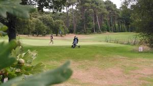 two people playing golf on a golf course at LE COURANT D'HUCHET in Moliets-et-Maa