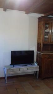 sala de estar con TV de pantalla plana sobre una mesa en Su Nuragi, en Santa Maria Navarrese