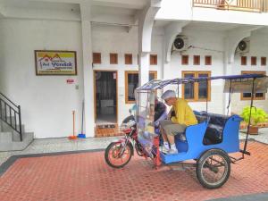 a man sitting on a small bike taxi at Pondok Simpang Tiga in Sabang