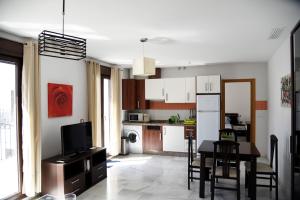 kuchnia i salon ze stołem i krzesłami w obiekcie Modern Atico, Close Macarena/Sevilla center w Sewilli