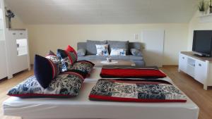 ein Wohnzimmer mit einem Sofa und Kissen auf einem Bett in der Unterkunft Ferienwohnung Giovanni in Schwandorf in Bayern