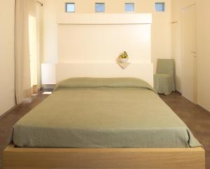 1 dormitorio con 1 cama con manta verde en Solea Relais di Charme- Adults only, en Trecastelli