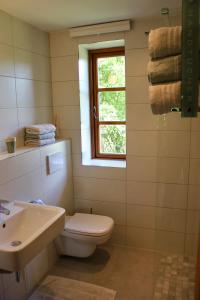 een badkamer met een toilet, een wastafel en een raam bij Kleine Auszeit in Kluis