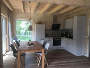 eine Küche und ein Esszimmer mit einem Holztisch und Stühlen in der Unterkunft Chalet Rotbuche in Potsdam