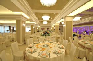 una sala per banchetti con tavoli bianchi e sedie bianche di Hotel Delle Canne ad Amantea Altre 44 foto
