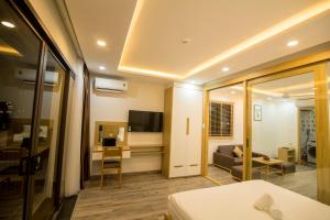 ダナンにあるTONY ESTATES Danang Beach Luxury Apartmentsのベッドとリビングルームが備わるホテルルームです。