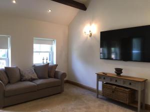 a living room with a couch and a flat screen tv at The Coach House in Southport