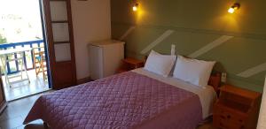 um quarto com uma cama com um edredão roxo em Fantasia House em Alonissos