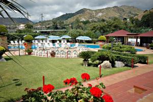 un resort con piscina, sedie e fiori di Hotel Delle Canne ad Amantea