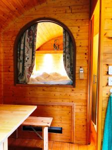 um pequeno quarto com uma janela num chalé de madeira em Millygite Chalet-on-wheels by the river em Milly-la-Forêt