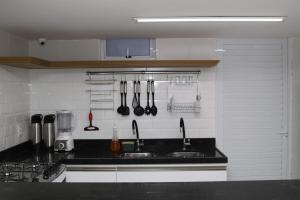 a kitchen counter with utensils hanging on the wall at Sonho de Iracema Hostel Boutique in Fortaleza