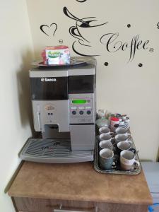 una macchinetta del caffè sopra un bancone con tazze di Silver Apartman a Eger