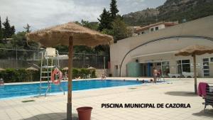 a swimming pool with an umbrella next to a building at Casa Buenavista Cazorla in Cazorla
