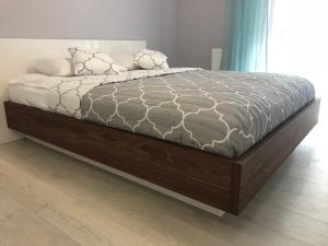 1 dormitorio con 1 cama grande con marco de madera en Apartament IDEAL, en Dziwnów