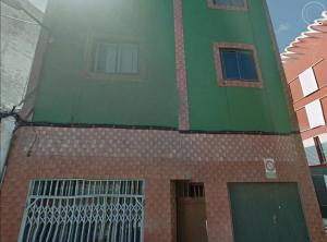 a green and red building with a gate on it at ATICO 2 in Las Lagunas