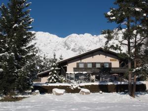 ein Haus mit schneebedeckten Bergen im Hintergrund in der Unterkunft Appartement Isabella in Mieming
