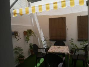 patio ze stołem, krzesłami i paskowym parasolem w obiekcie El apartamento de Ana -Jerez w mieście Jerez de la Frontera