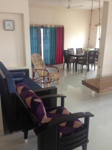 a living room with chairs and a blue couch at Haritham in Tiruchchirāppalli