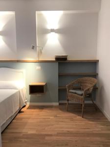 オルベテッロにあるCinema House Apartmentsのベッドルーム1室(ベッド1台、椅子、照明付)